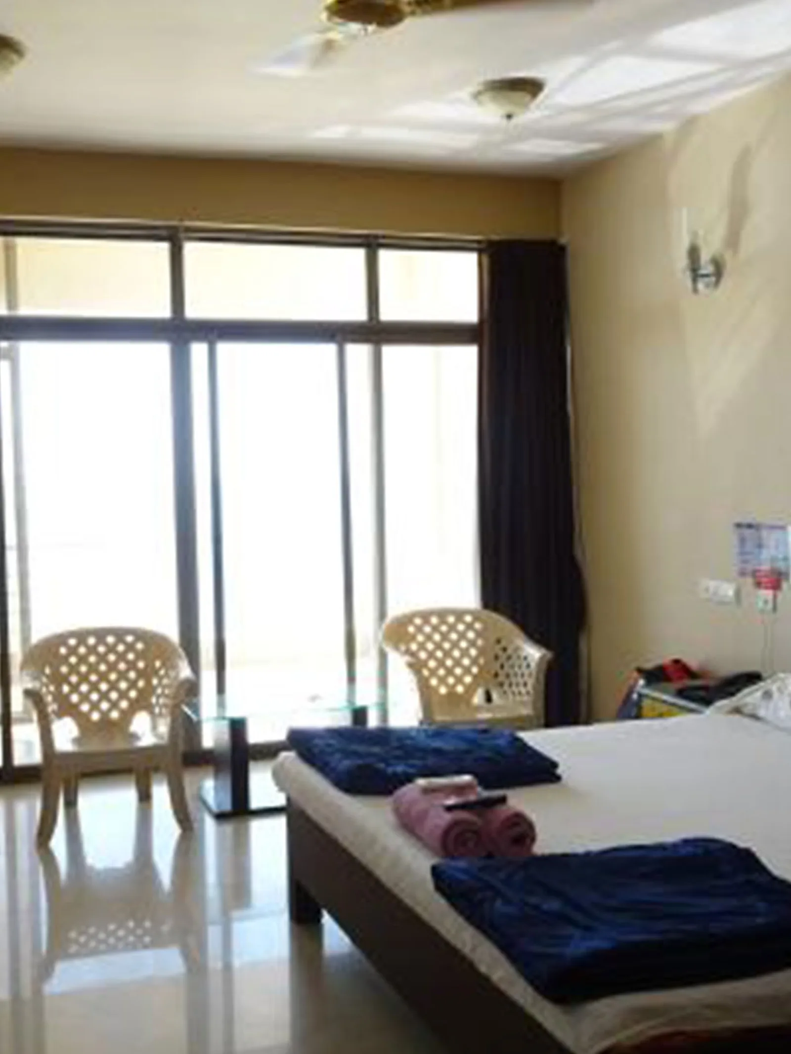 Guest room with two chairs and a small table beside the sea facing glazed door